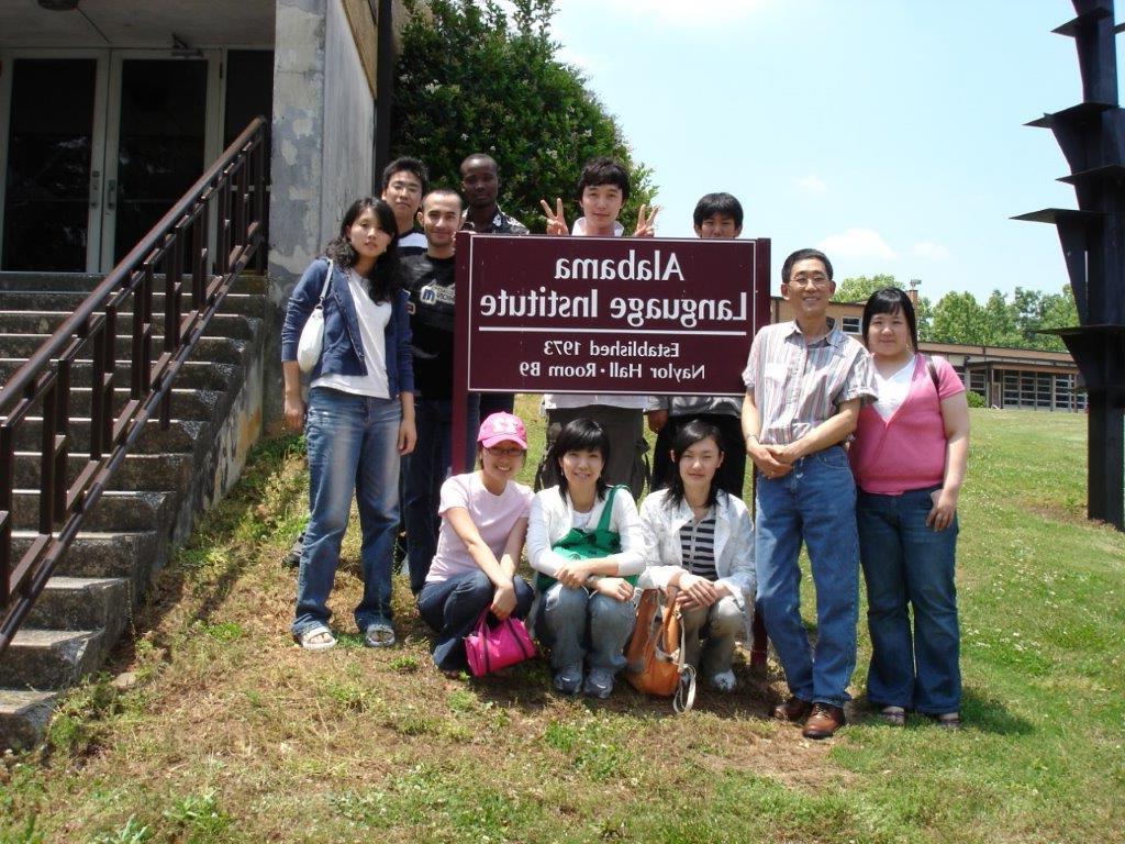 拿着阿拉巴马语言学院标牌的学生